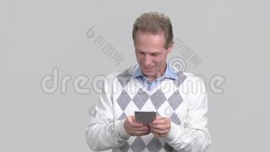 微笑的中年男人使用智能手机。